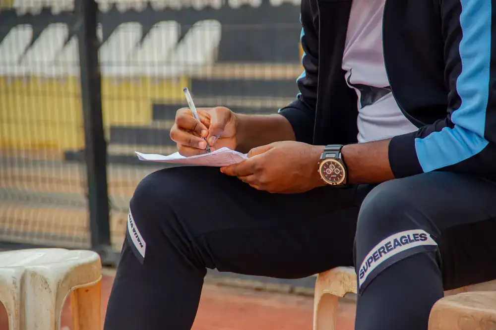 Coach taking notes while watching a player perform